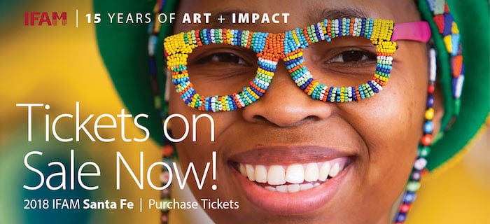 A poster for the International Folk Art Market in Santa Fe, New Mexico, shows a woman wearing brightly colored beaded eyeglasses