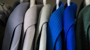 A row of coats neatly hung in a closet