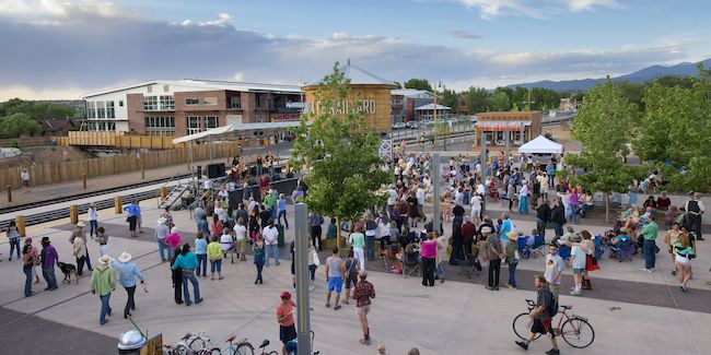 A view of the Santa Fe Railyard in Santa Fe, New Mexico with people walking, sitting, and biking