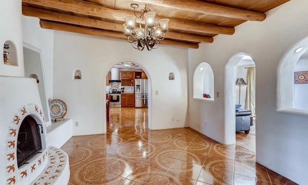 The interior of a Santa Fe home with a traditional fireplace and tiled floor
