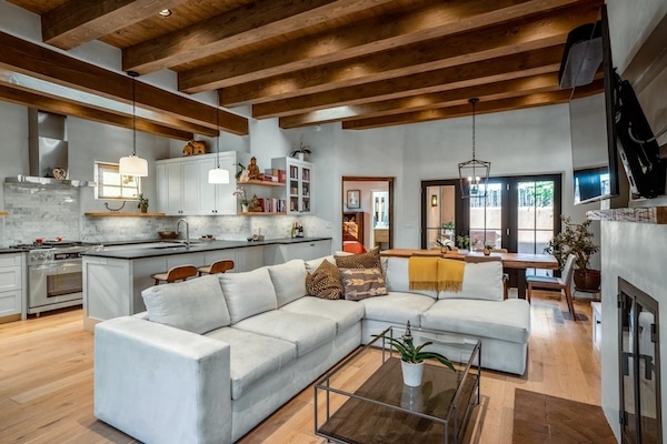 The living room of a Santa Fe home in the picturesque Guadalupe Historic District. The open-concept living area is flooded with natural light from skylights, windows, and French doors.