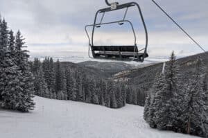 An empty ski lift at Ski Santa Fe with evergreen trees in the background