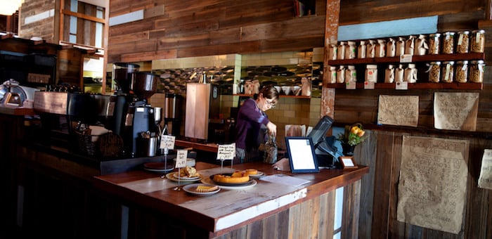 The interior of Caveman Coffee in Santa Fe, New Mexico, with a barista preparing an order of coffee