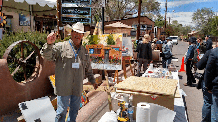 An artist painting a picture at the Canyon Road Spring Art Festival in Santa Fe, New Mexico