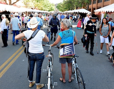Couple on bicycles in downtown Santa Fe during Indian Market