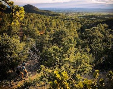 Mountain biker riding down a trail overlooking Santa Fe
