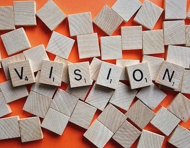 The word "vision" spelled out in Scrabble blocks