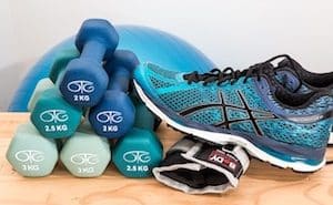A stack of lightweight dumbbells and an athletic shoe