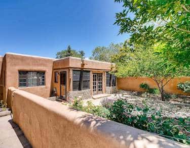 An adobe wall and courtayrd to the front entrance of a home in Santa Fe