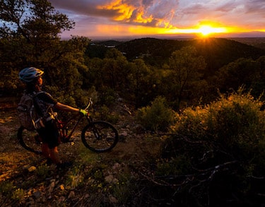 A mountain biker takes in an amazing sunset on the Dale Ball trails in Santa Fe