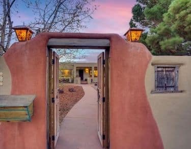 Adobe gated entryway to a flat roof Santa Fe home