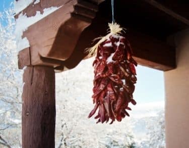 Chile ristra hanging from a porch covered in snow