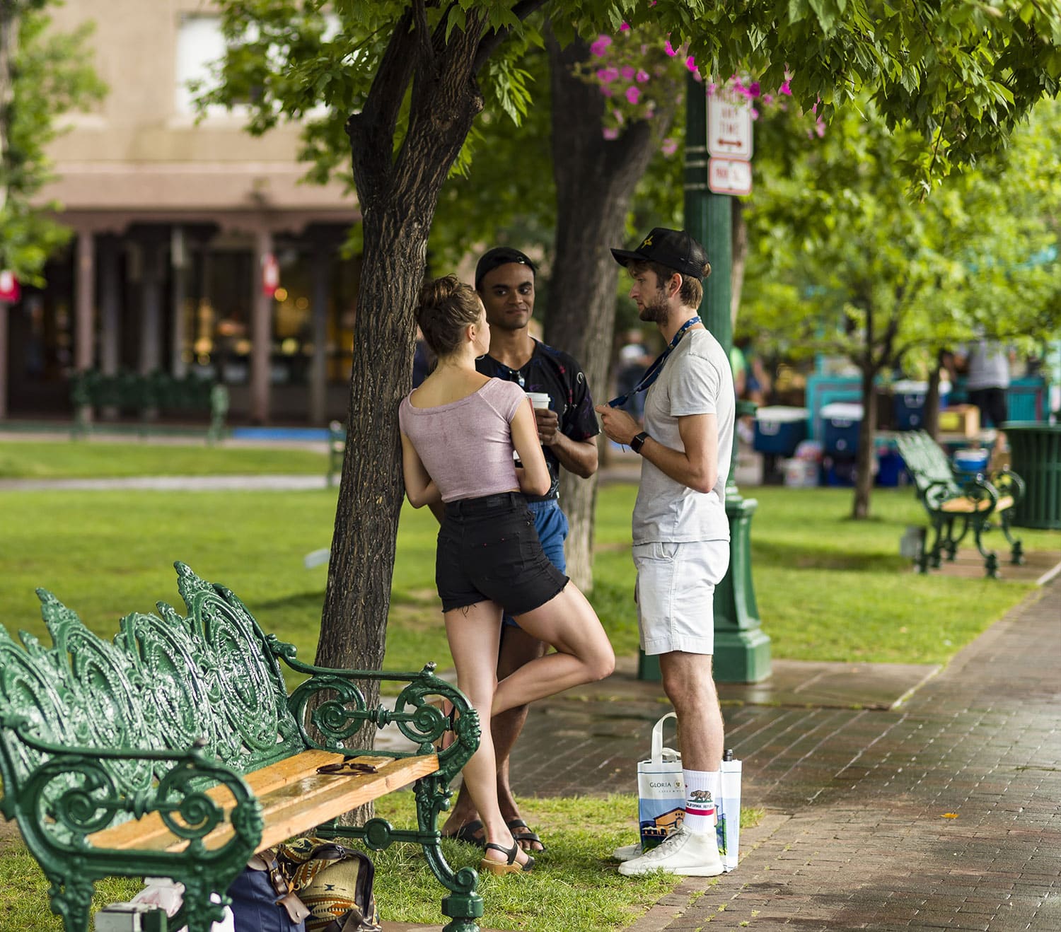 Two boys and a girl chat while standing at the Santa Fe Plaza.