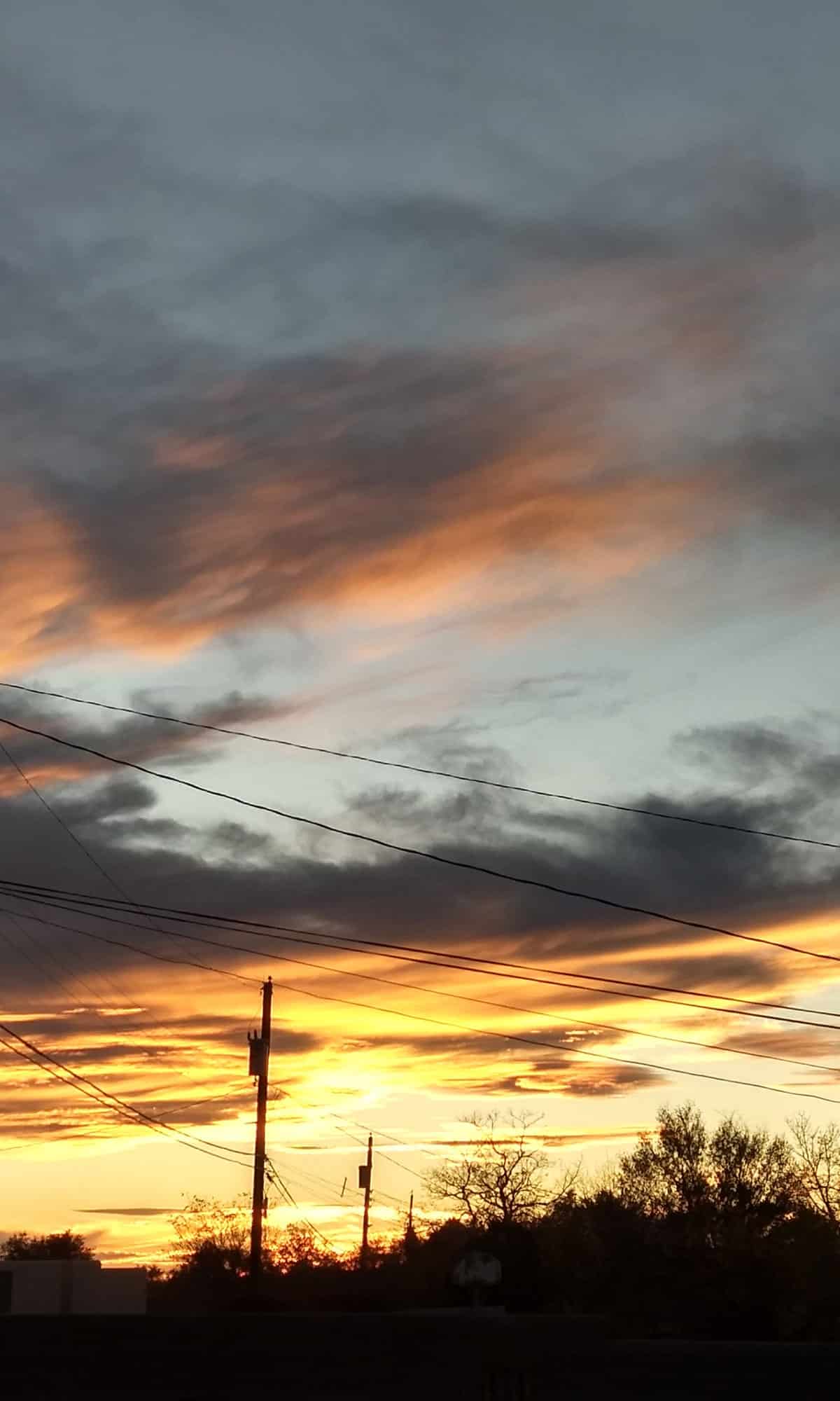 Sunset with power lines in the foreground.